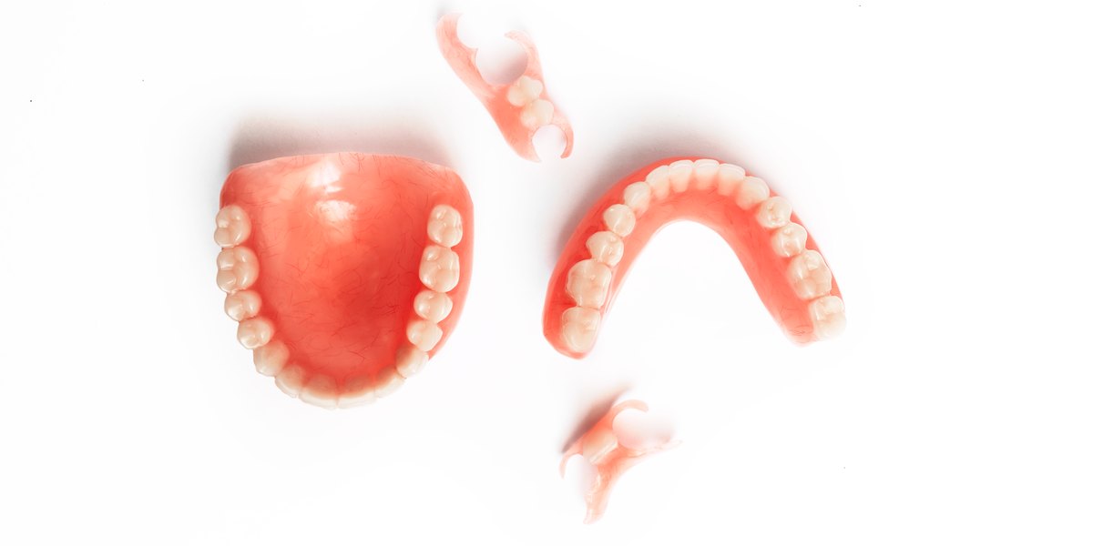 Dientes provisionales: dentaduras de resina y pequeñas prótesis parciales de quita y pon sobre fondo blanco