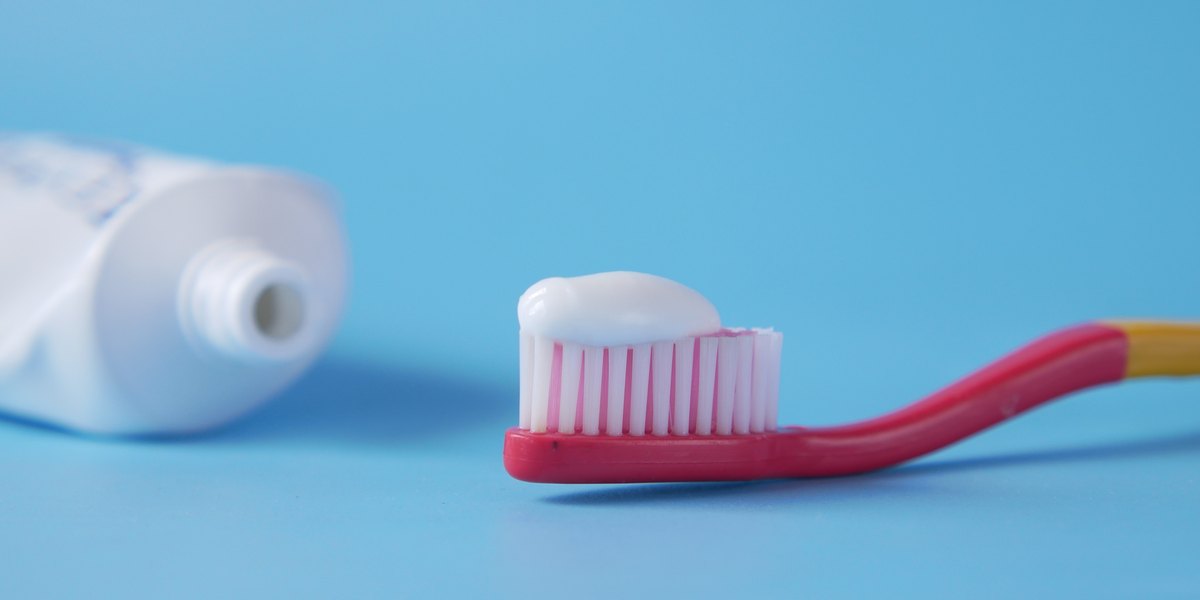 Pasta de dientes blanqueadora: cepillo de dientes con pasta sobre fondo azul