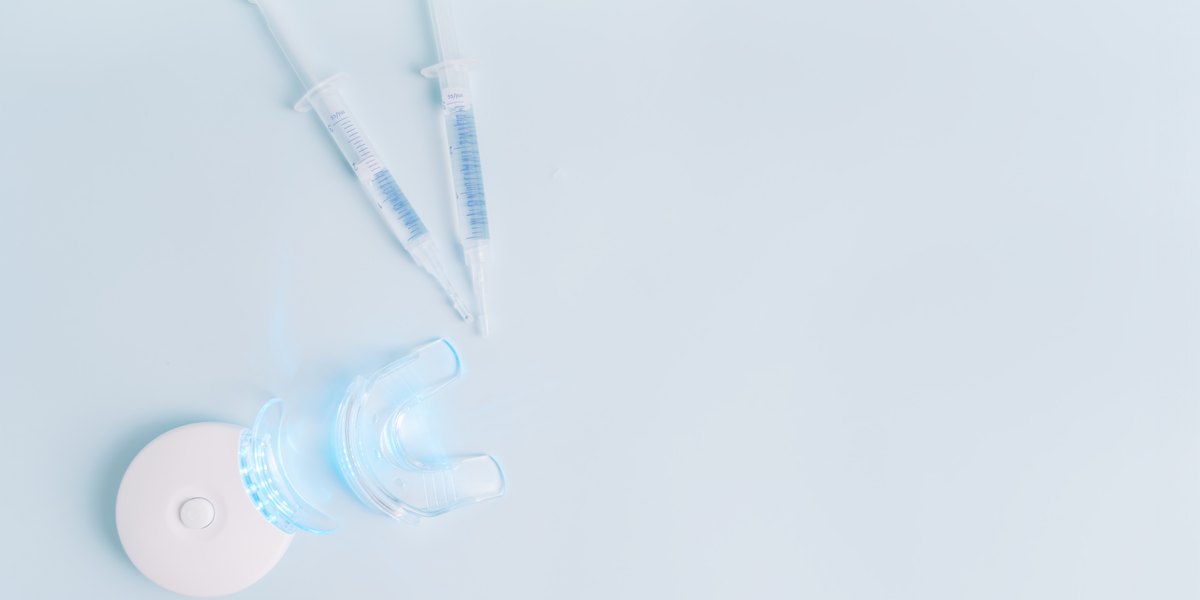 Peróxido de carbamida: jeringas de gel blanqueador y una férula transparente sobre fondo azul claro